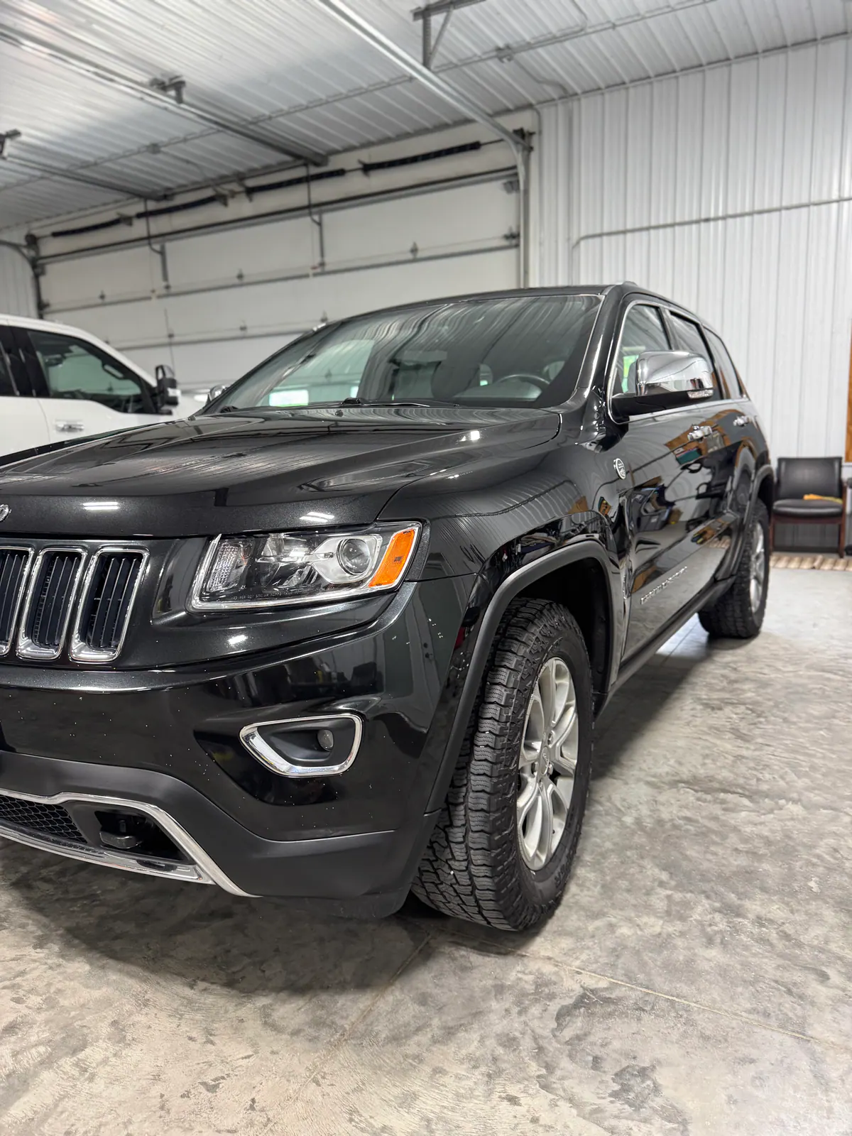 Freshly detailed black Jeep SUV inside the Premier Coatings shop