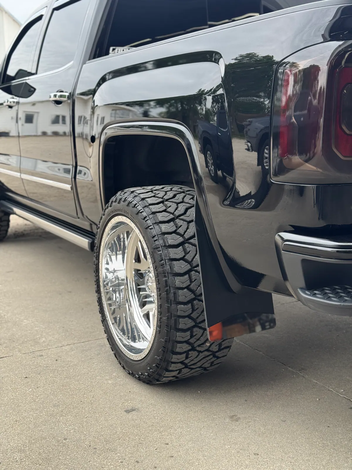 Detailed black GMC truck bed and rear wheel with clear reflections