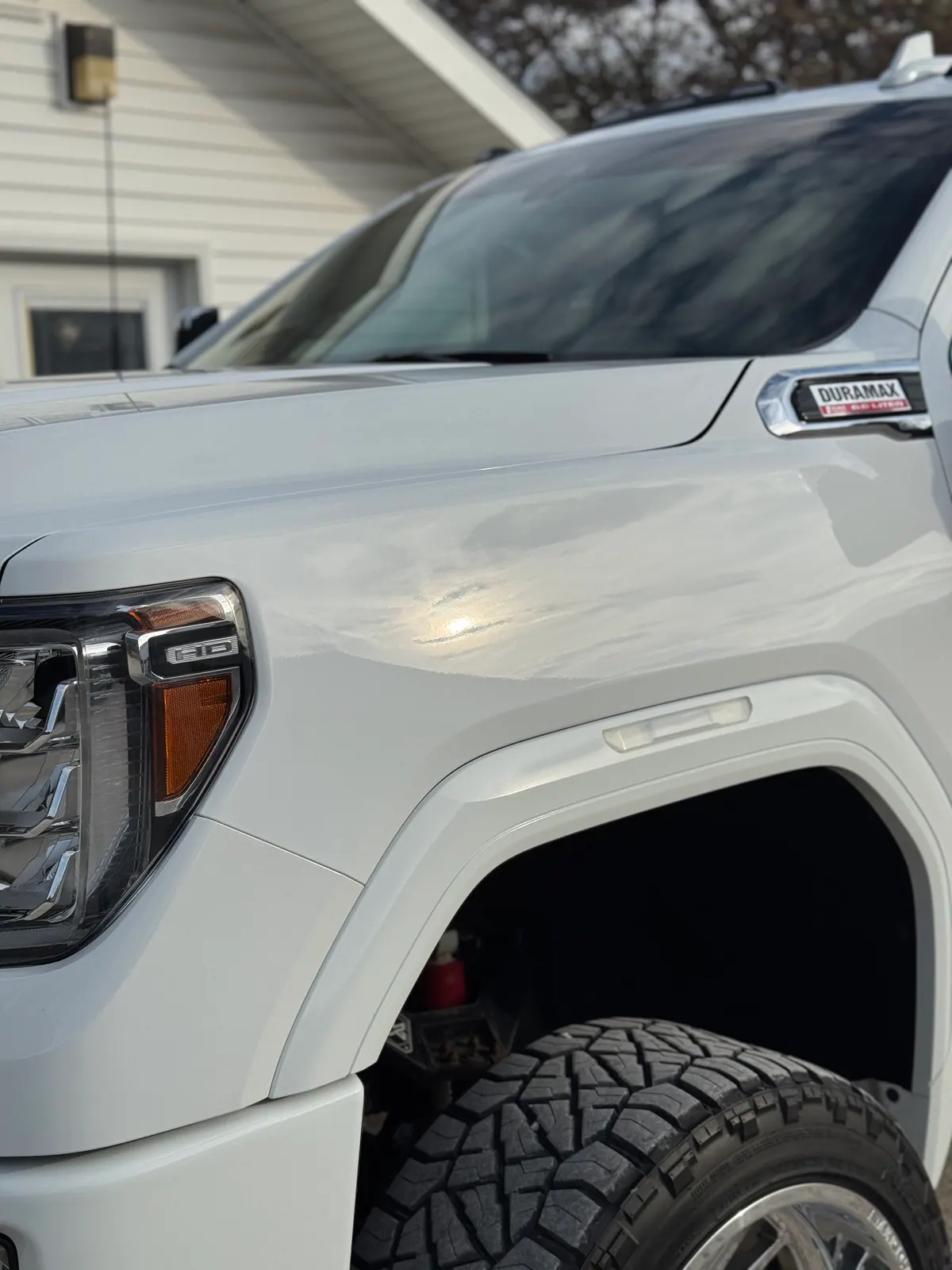 Detailed white GMC truck fender and wheel showing a clean bright finish