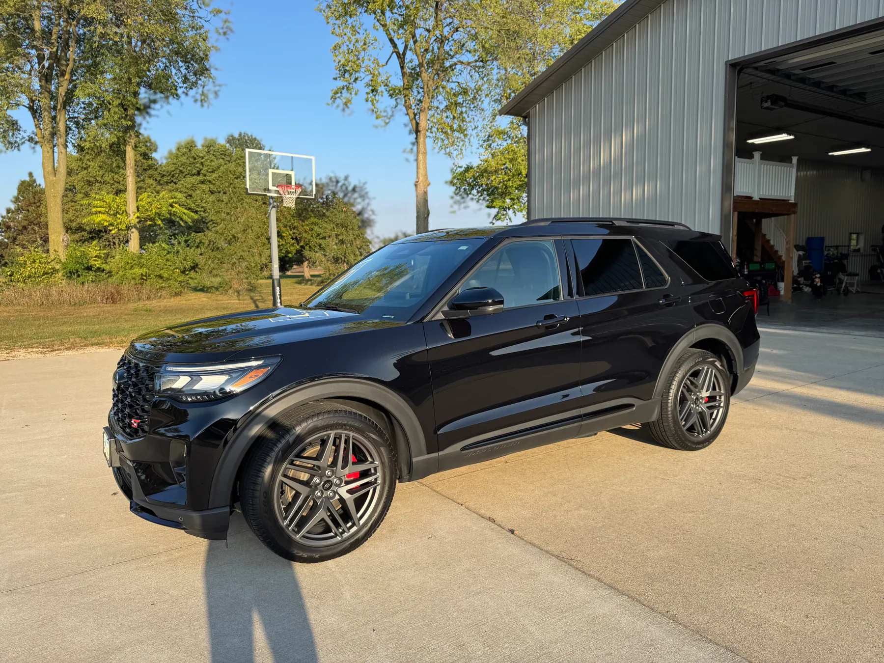 Black Ford Explorer parked outside a large garage