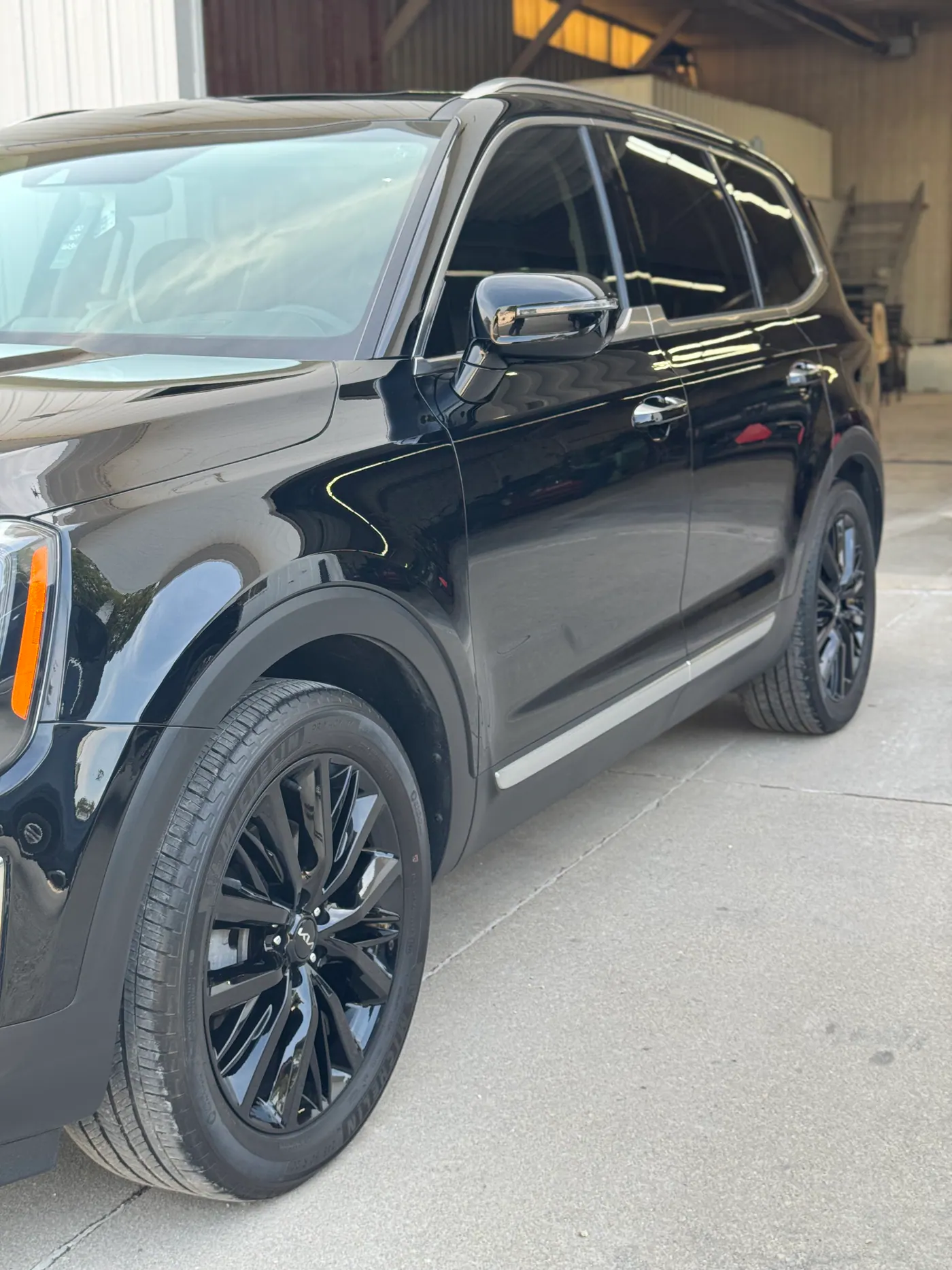 Black SUV with glossy body panels outside a shop