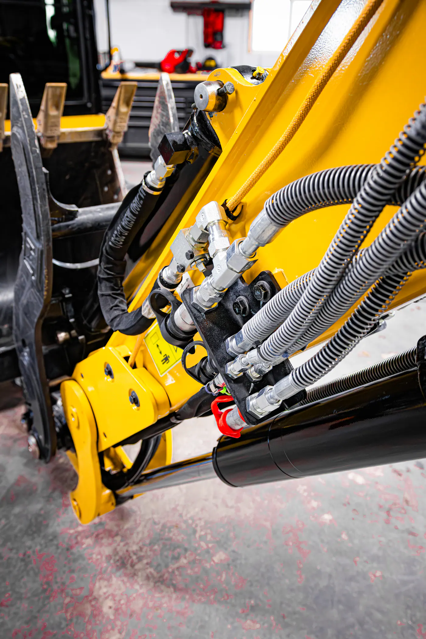 Hydraulic lines and yellow boom components on an excavator