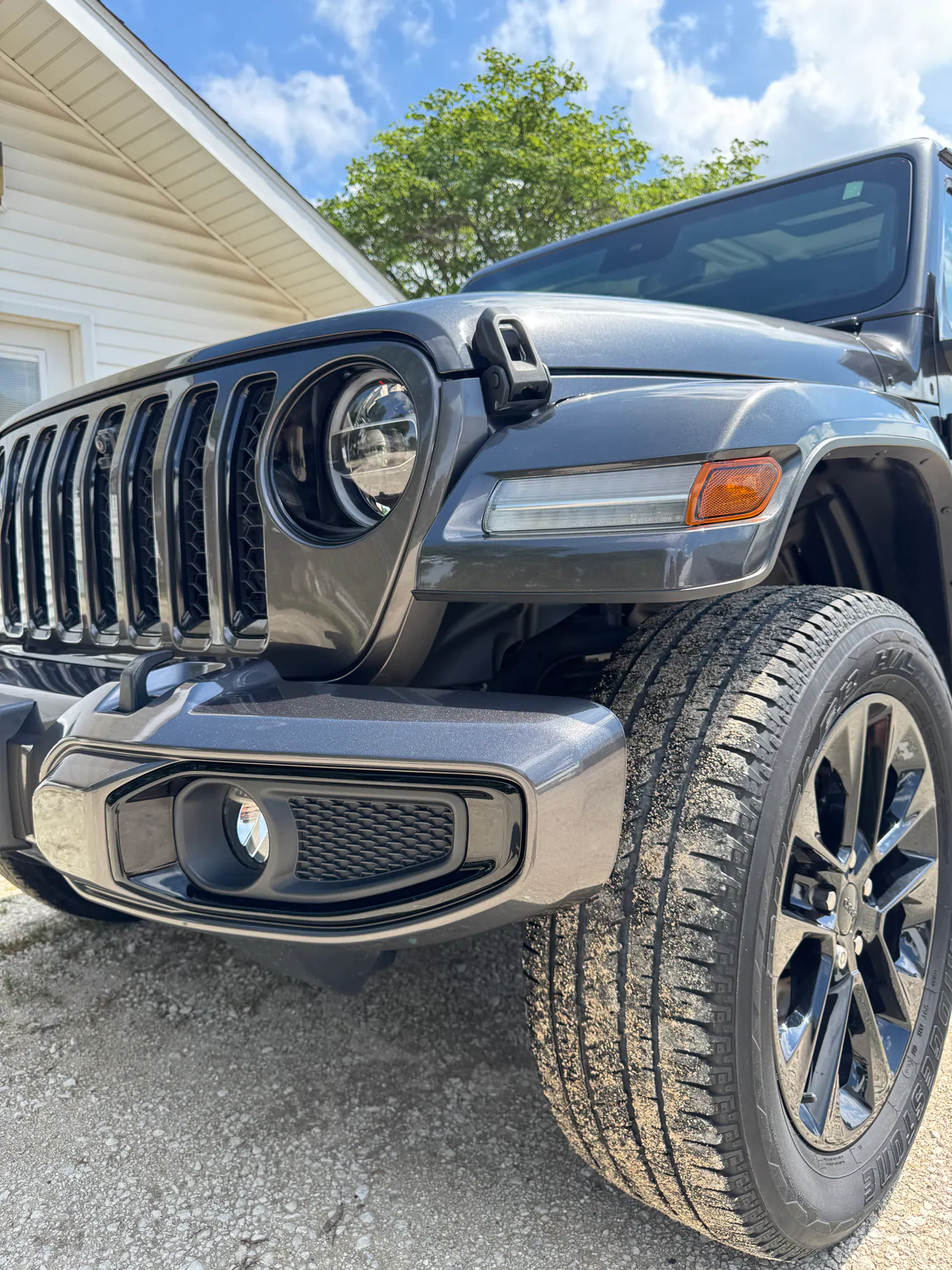 Gray Jeep front end and wheel photographed outdoors