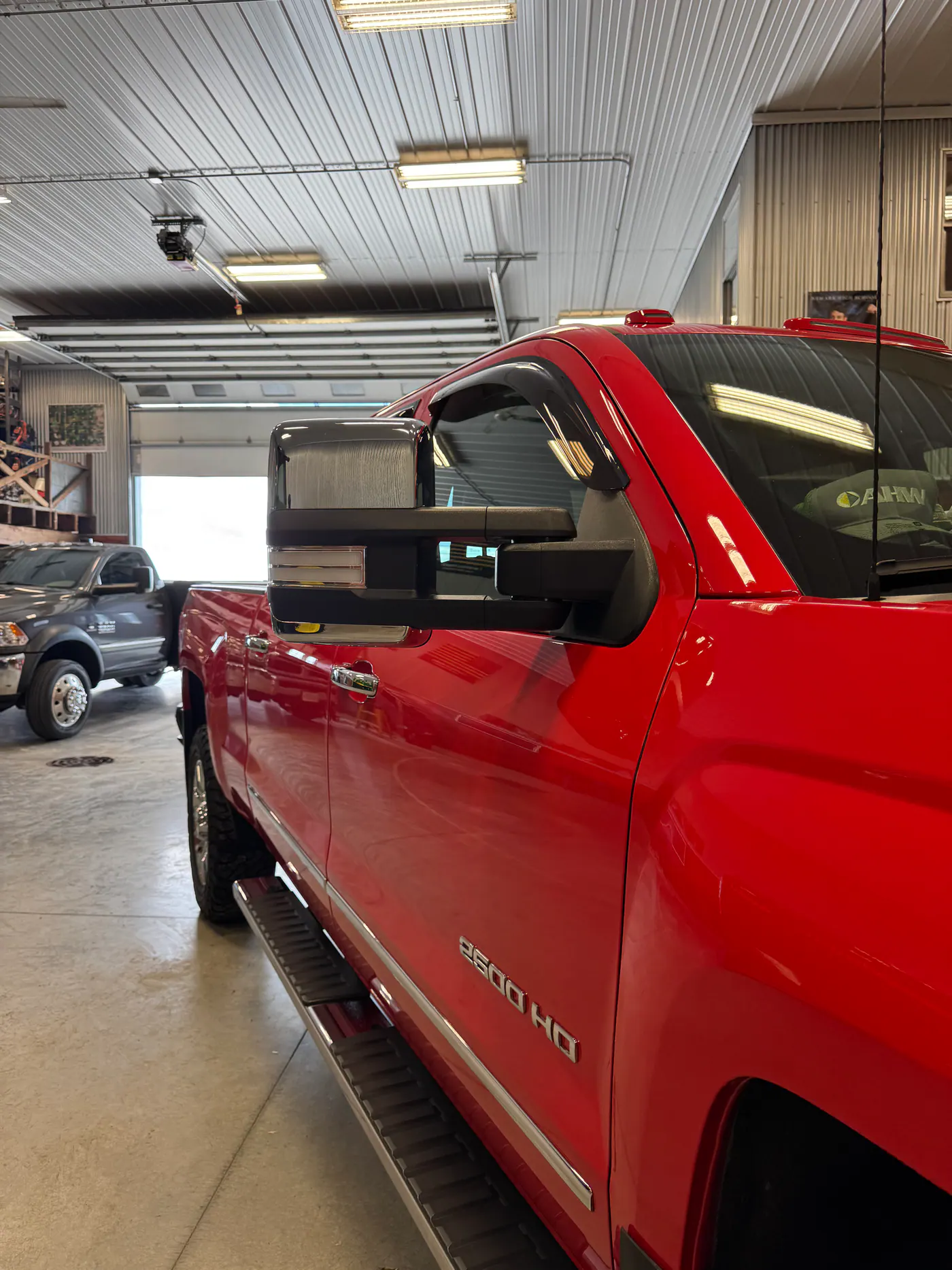Red Chevrolet 2500 HD pickup inside a large shop