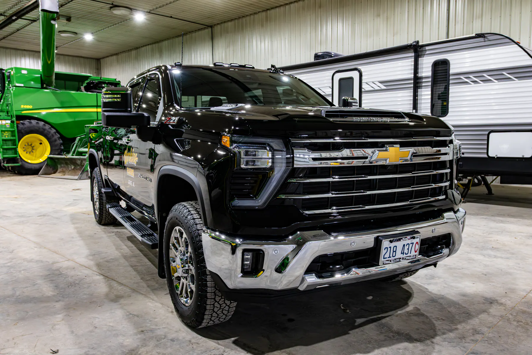 Black Chevrolet pickup finished inside a large equipment shop